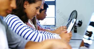 教室里使用数字平板电脑和笔记本电脑的学生